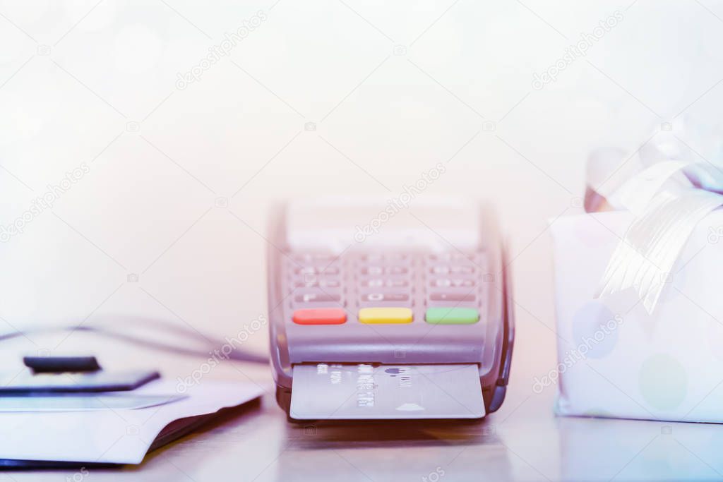 Credit card and chip reader machine, on table with gift box shallow DOF for background