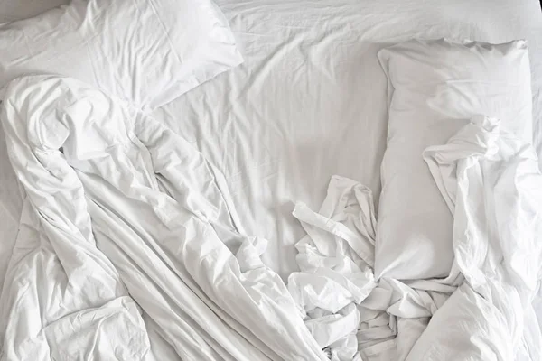 Вид зверху на білі простирадла для постільної білизни та подушку, біла тканина зморщена текстура — стокове фото