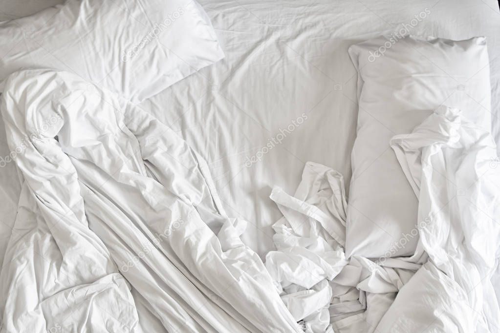 Top view of white bedding sheets and pillow ,white fabric wrinkled texture