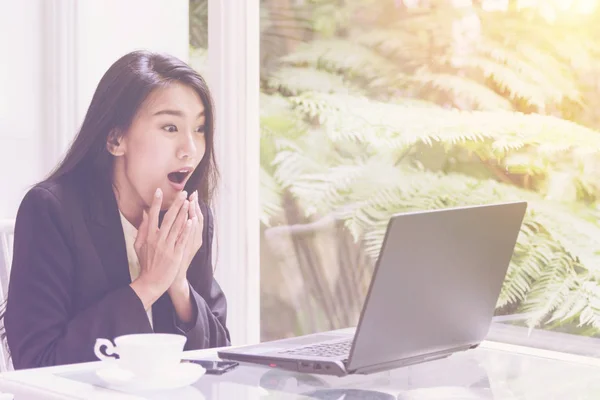 Gyönyörű fiatal üzleti nő dolgozik laptop, látszó képernyő gesztus örvendezés, sokk, meglepetés érzelem — Stock Fotó