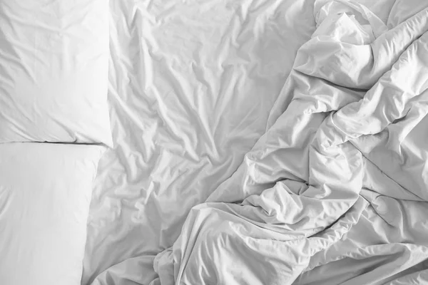 Bed sheets and pillows messed up after nights sleep ,comfort and bedding in a hotel room, concept travel and vacation — Stock Photo, Image