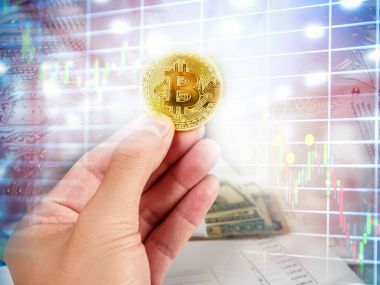 Altın Bitcoin borsa grafik arka planı üzerinde tutan el