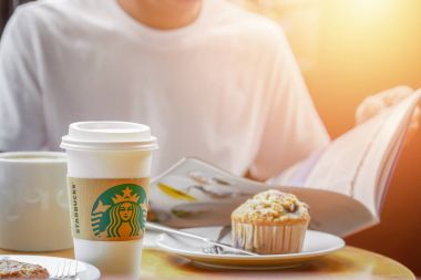 Bangkok, Tayland, 17 Haziran 2017: Starbucks bir bardak sıcak içecek insanlar haber okuma tabloyla, mola süresi Starbucks kafede kahve.