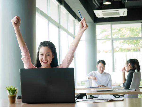 Cheering happy business people ,Happy business team with arm raised sitting at desk in office during an office monthly meeting success, business concept background ,Activity moving blurred