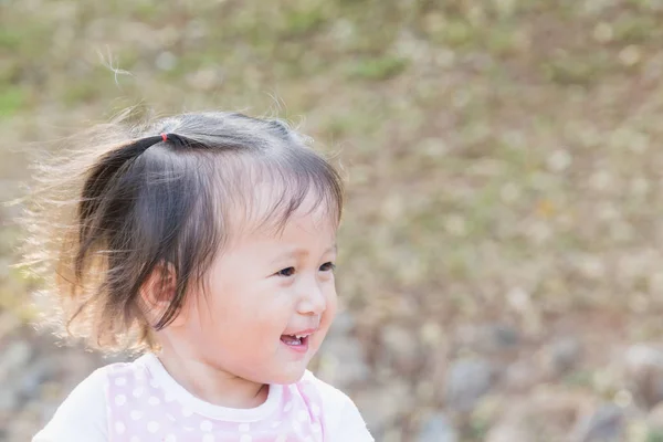 Kleine meisje glimlach: glimlachen meisje loopt Gelukkig in het park met haar familie zonsondergang tijd — Stockfoto