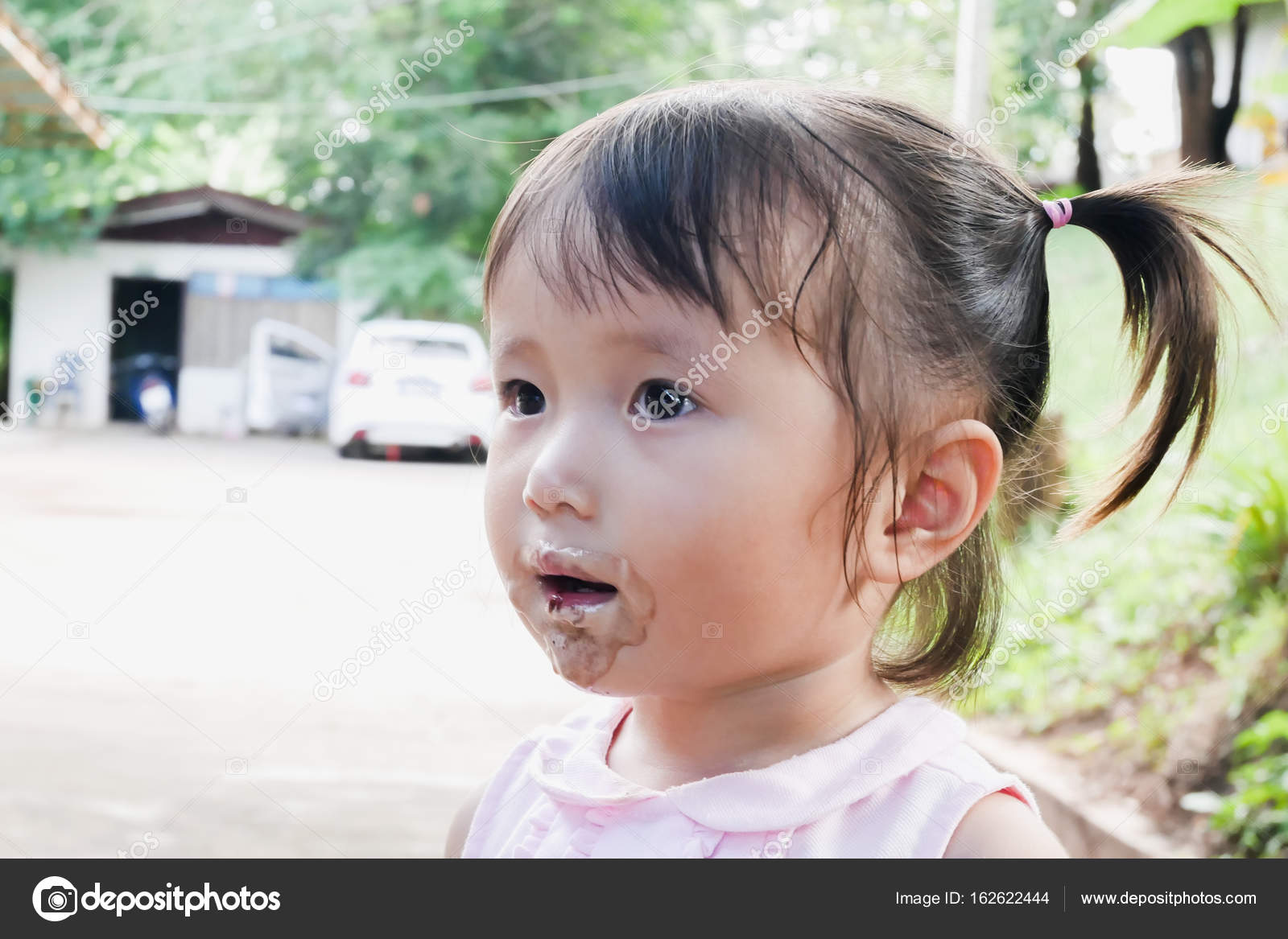 La bambina mangia il gelato con la sua bocca imbrattato di gelato nel parco — Foto di jes2uphoto