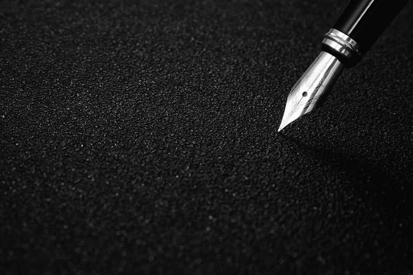 Фонтанна ручка з відсічним контуром на чорному текстурованому фоні для концепції підпису — стокове фото