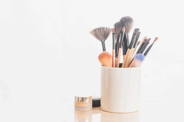 Make up brushes in holder and cosmetics isolated on white — Stock Photo, Image