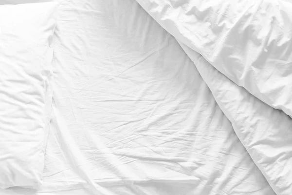 Unmade bed with crumpled bed sheet, a blanket and pillows after comfort duvet sleep waking up in the morning — Stock Photo, Image