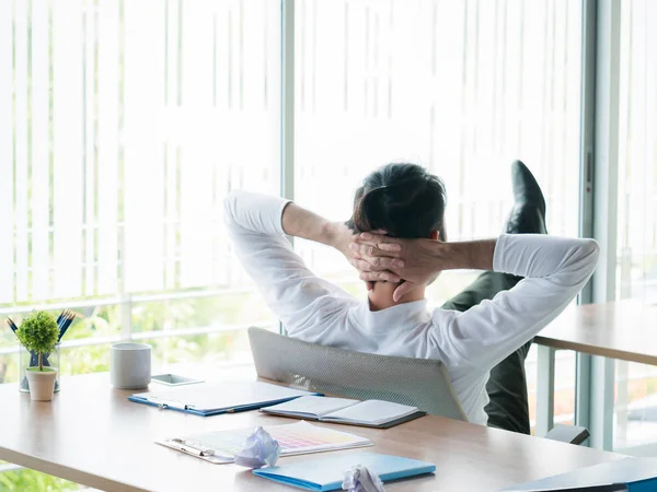 Zakenman ontspannen concept: zakenman zitten met de voeten op Bureau kijken uit het raam in de rest van de tijd — Stockfoto