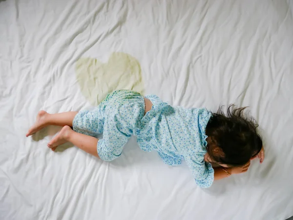 Bedwetting: Bir yatak, küçük kız ayak ve sidik çarşaf, çocuk geliştirme kavramı, içinde çocuk işerim ıslak yatakta odak seçili.