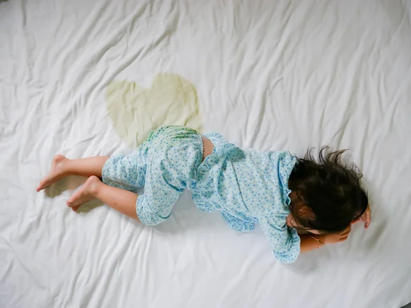 Постільна білизна: дитяча пісяти на матраці, маленька дівчинка ноги і пісяти на простирадлі, концепція розвитку дитини, вибраний акцент на мокрій на ліжку — стокове фото
