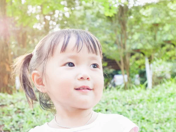 Portret van spelen in de groene tuin met warme toon en soft focus ondervraagt Aziatische baby meisje — Stockfoto