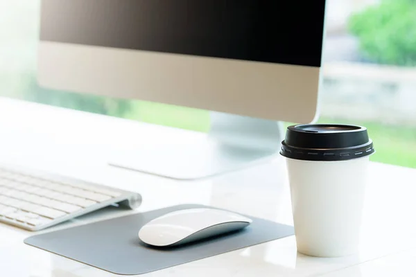 Primo piano di Monouso Coffee Cup e Computer in caffetteria concetto per lo spazio libero per lavorare in caffetteria . — Foto Stock