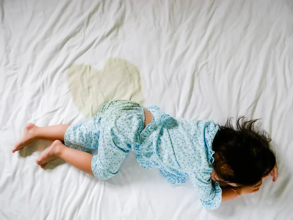 Çocuk bir yatak, küçük kız ayak ve sidik içinde çarşaf, çocuk geliştirme kavramı, işerim odak seçili — Stok fotoğraf