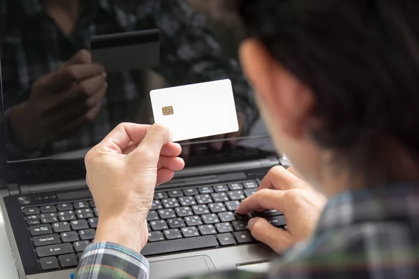 Manos masculinas sosteniendo números de escritura de tarjetas de crédito en el teclado de la computadora: concepto de compras en línea — Foto de Stock