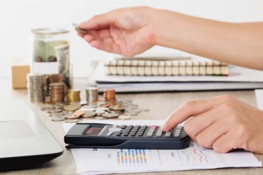 hesap makinesi iş diyagram üzerinde mali raporu konteyner bankaya sikke ve para madeni para koyarak el ile kullanarak iş adamı