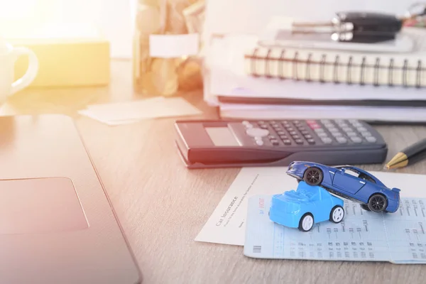 Bil försäkring: konceptbil ansökningsformuläret med bil leksak krasch på skrivbord — Stockfoto