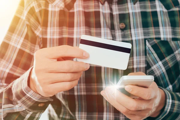 Joven con tarjeta de crédito y el uso de teléfono inteligente pagar compras concepto en línea — Foto de Stock