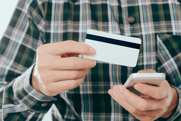 Joven con tarjeta de crédito y utilizar el teléfono inteligente para pagar o comprar concepto en línea — Foto de Stock