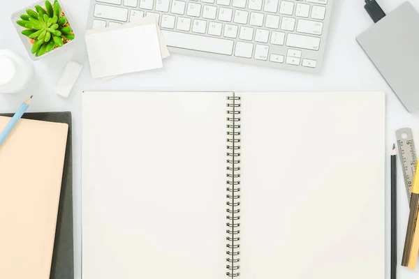 Blank notebook page on modern white office desk table with supplies for mockup. Top view, flat lay — Stock Photo, Image