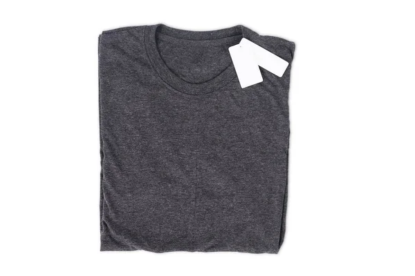 Gevouwen t-shirt met tag isoleren op witte achtergrond met uitknippad voor ontwerp mockup — Stockfoto