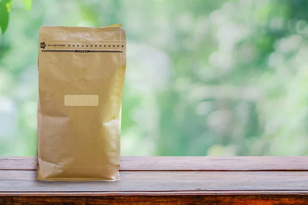Opakowanie papierowe wąchanie otworu, Opakowanie ziarna kawy zapach wafting kawy na drewnianym stole z Clipping ścieżki na papierowej torbie i etykiecie — Zdjęcie stockowe