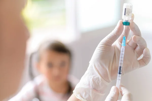 Médico de la mano con jeringa médica en la mano listo para la inyección a un niño pequeño vacunado Inyección — Foto de Stock