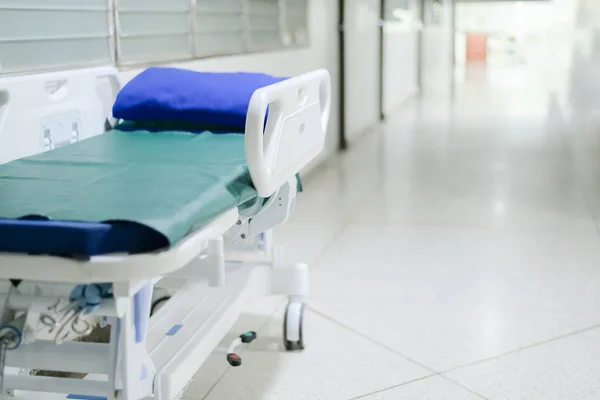 Abstract blurred hospital corridor path way with blank patient bed for background — Stock Photo, Image