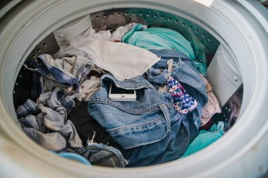 Çamaşır makinesinde akıllı telefon, cepte unutulmuş cep telefonu, pantolon ya da gömlek.