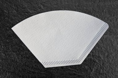 Kağıtları her türlü filtre kahve makinesi ve markası için kırpma yolu olan koyu bir masa arkaplanında izole et.