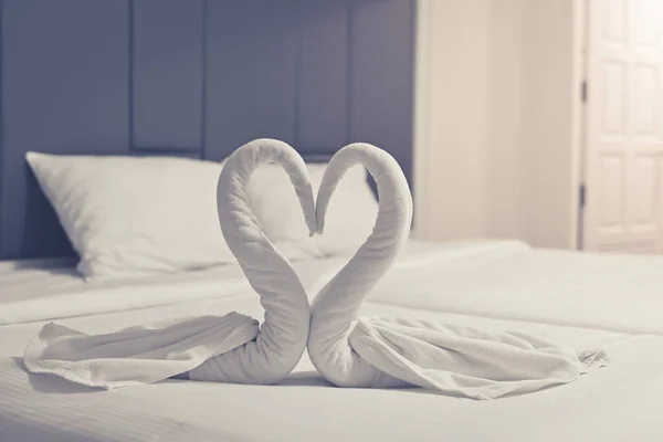 Comfortable bedroom,Towels arranged as swans heart in the bedroom for romance decorative trip