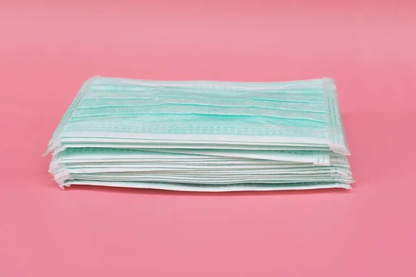 Heap of Medical face mask, Medical protective mask on pink background. Disposable surgical face mask cover the mouth and nose. protect Healthcare and medical concept.