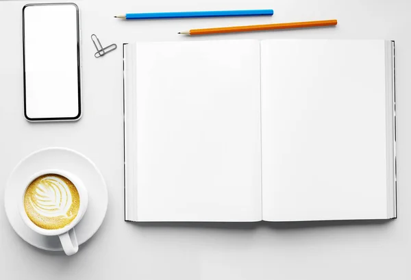 空のオープンブックと空白の白い画面テーブルの上にコーヒーカップと鉛筆でスマートフォン 簡単に白い画面のラップトップモックアップ 3Dイラストであなたのデザインを置き換え — ストック写真