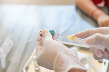 Doktor Hand ve şırınga şırıngası iğne şişelerini kapatan hastaya aşı ya da aşı hazırlayın.