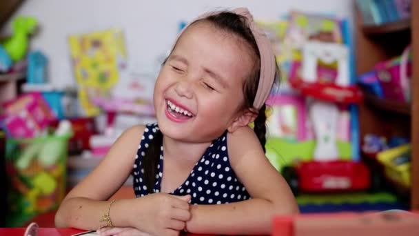 Zblízka holčička se směje a usmívá poté, co slyšel vtip příběh od matky v domácí rodině — Stock video