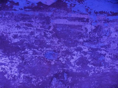 Beton bir duvarın dokusu ve eski boya lekeleri. Soyut arka plan koyu maviye boyanmış. 2020 Yılının Rengi Klasik Mavi Pantolon