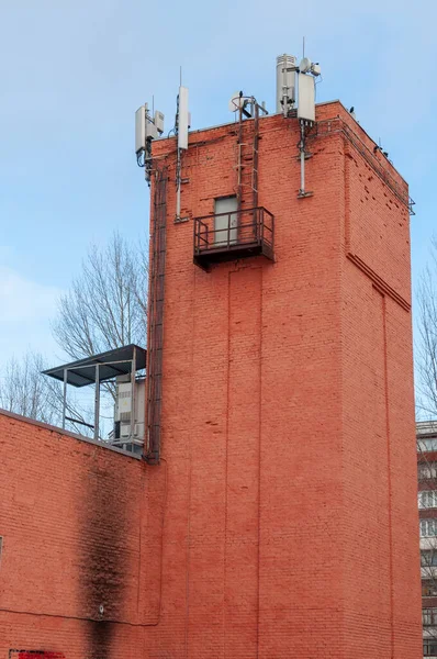 Hücresel iletişim ve veri iletimi için ekipman. 2G, 3G, 4G, 5G antenleri eski bir tuğla su kulesinin çatısına kurulmuş.