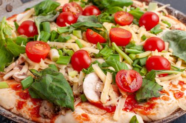 Mantarlı taze çiğ pizza, kiraz domatesleri, fesleğen ve parmesan peyniri. Pişirmeden önce ev yapımı pizza.