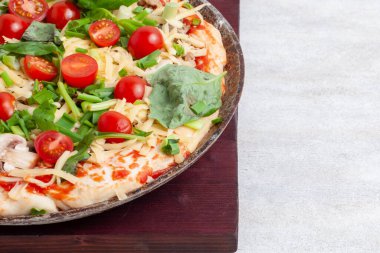 Mantarlı taze çiğ pizza, kiraz domatesli, Basil ve Parmesan yuvarlak bir tavada fotokopi alanı olan beyaz bir arka planda. Pişirmeden önce ev yapımı pizza.