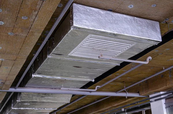 Ceiling insulation, ventilation system air ducts, fire extinguishing system pipes, electric cable channels under the ceiling of the Parking lot on the open ground floor of the building