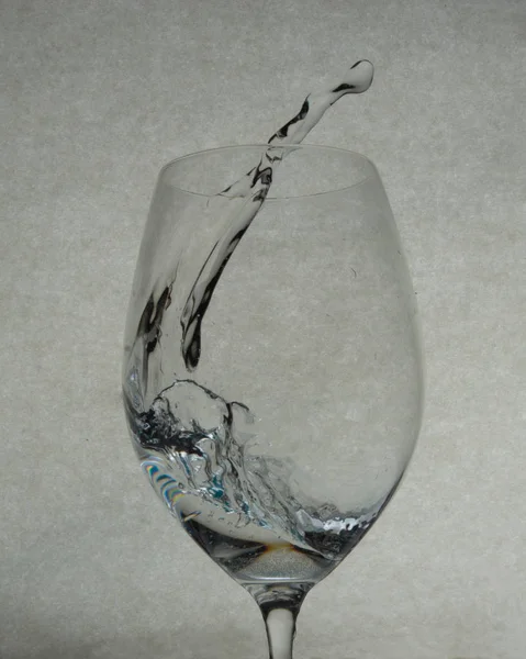 ワイングラスの中の保持水スプラッシュ — ストック写真