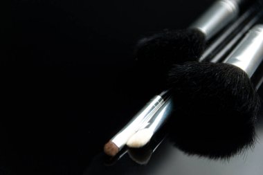 Siyah cam masada duran makyaj fırçaları. Seçici odaklı fotoğraf, düşük tuşlu fotoğraf
