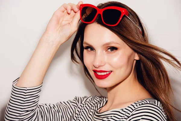 Alta moda look.glamor elegante bela jovem feliz sorridente mulher modelo com lábios vermelhos e óculos de sol vermelhos — Fotografia de Stock