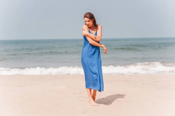 Beautiful girl standing near by the beach in blue dress Stock Photo