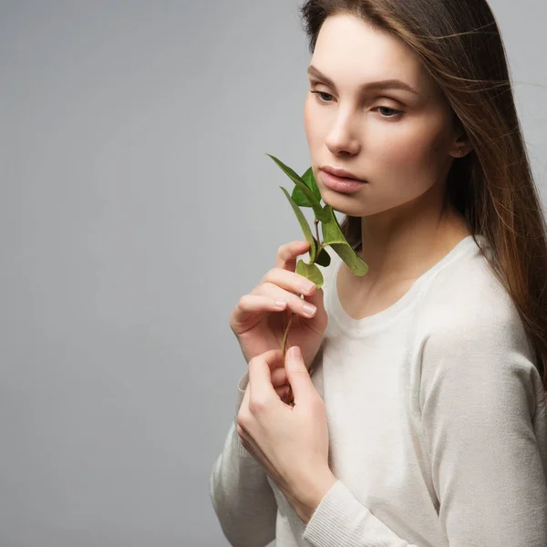 Vacker kvinna med gröna blad — Stockfoto