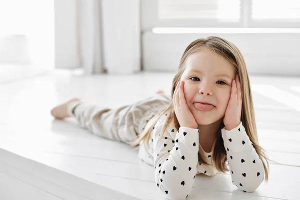 A little girl sitting on a table Stock Picture