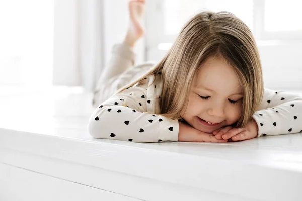A little girl sitting on a bed Stock Photo