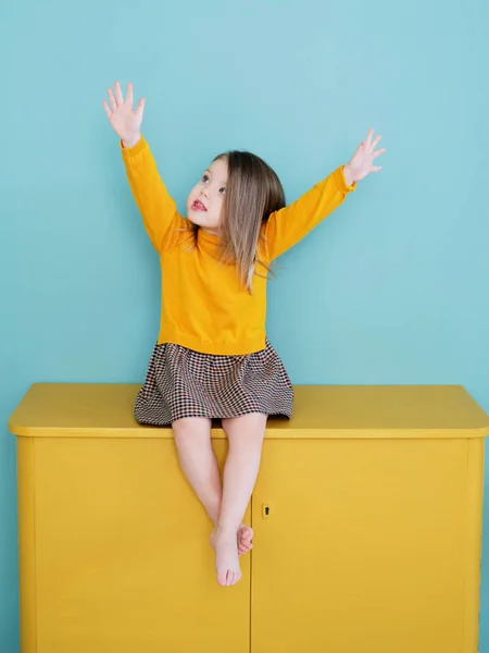 Een jong meisje met een geel shirt aan Stockfoto