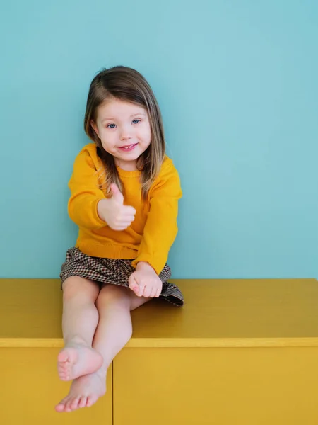 Een klein meisje in een geel shirt Rechtenvrije Stockafbeeldingen